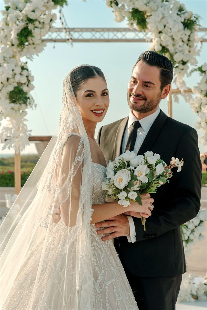 Bride and groom smiling at a beach wedding